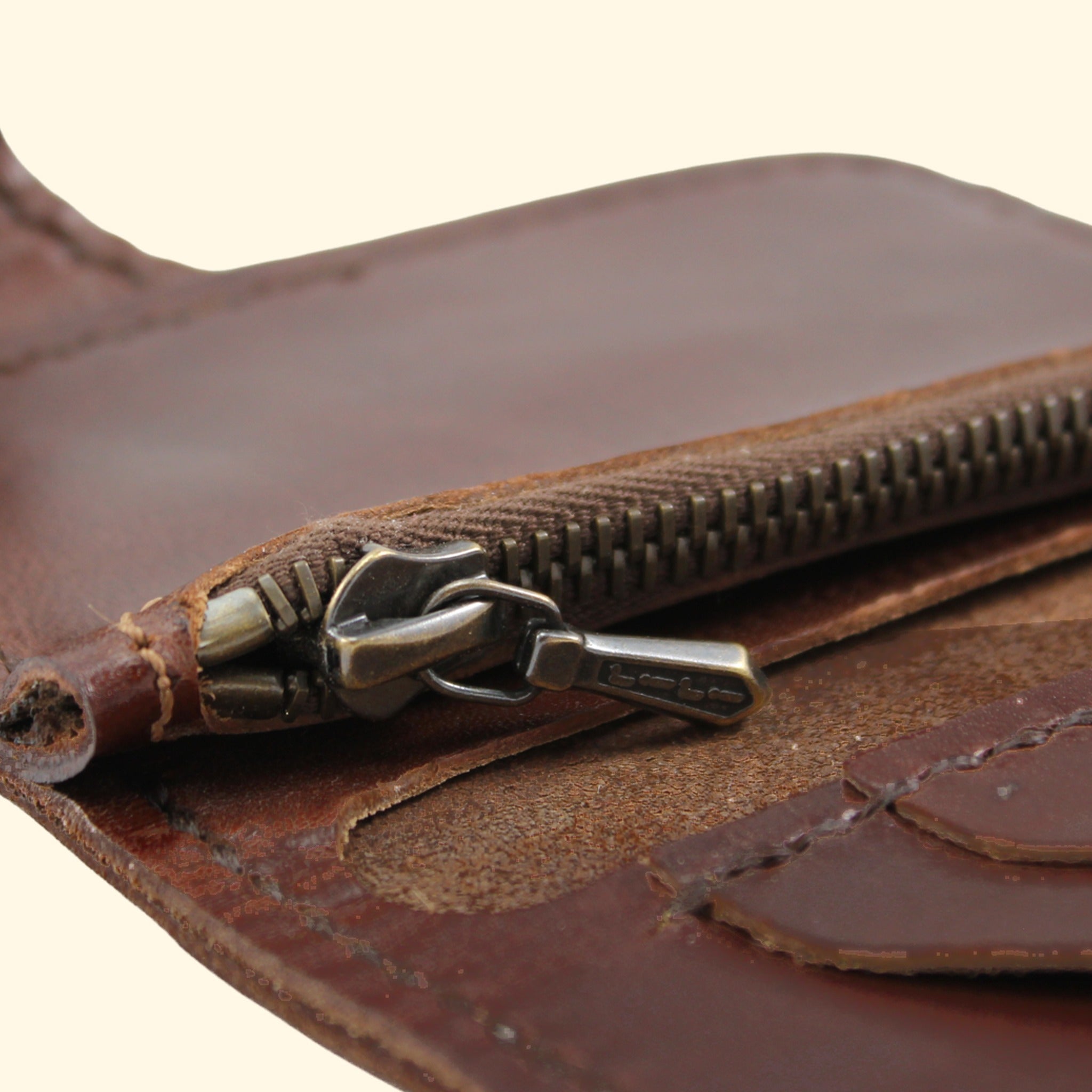 Riri-Reissverschluss im Detail am dunkelbraunen Oldpassion Snap Wallet mit dunkelbraunem Faden