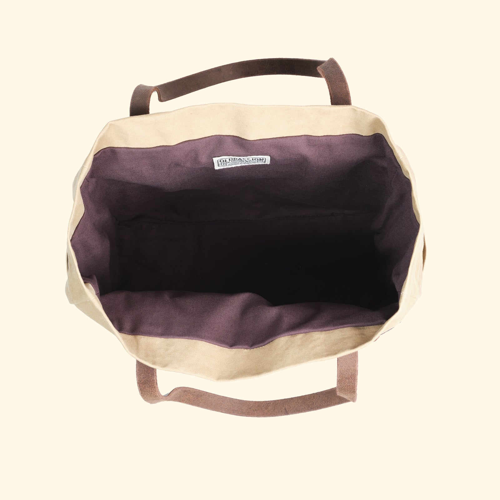 Innenansicht der Canvas Tote Bag in Sandfarbe von oldpassion – geräumiges Hauptfach mit dunkelviolettem Innenfutter und Markenlabel, handgefertigt in der Schweiz.
