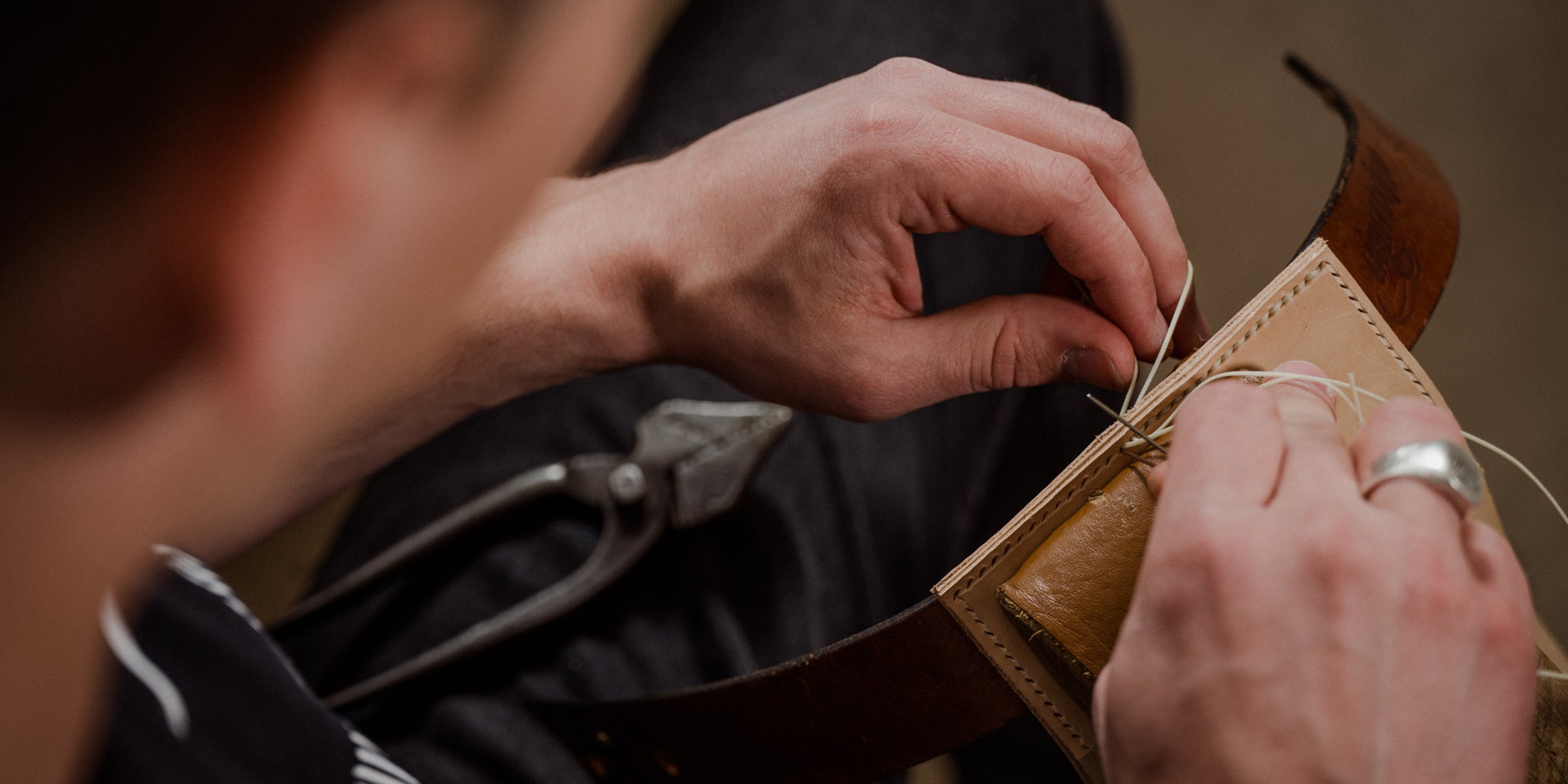 Handgefertigte oldpassion Lederwaren: ein Lederstück wird von Hand mit dem Sattlerstich vernäht