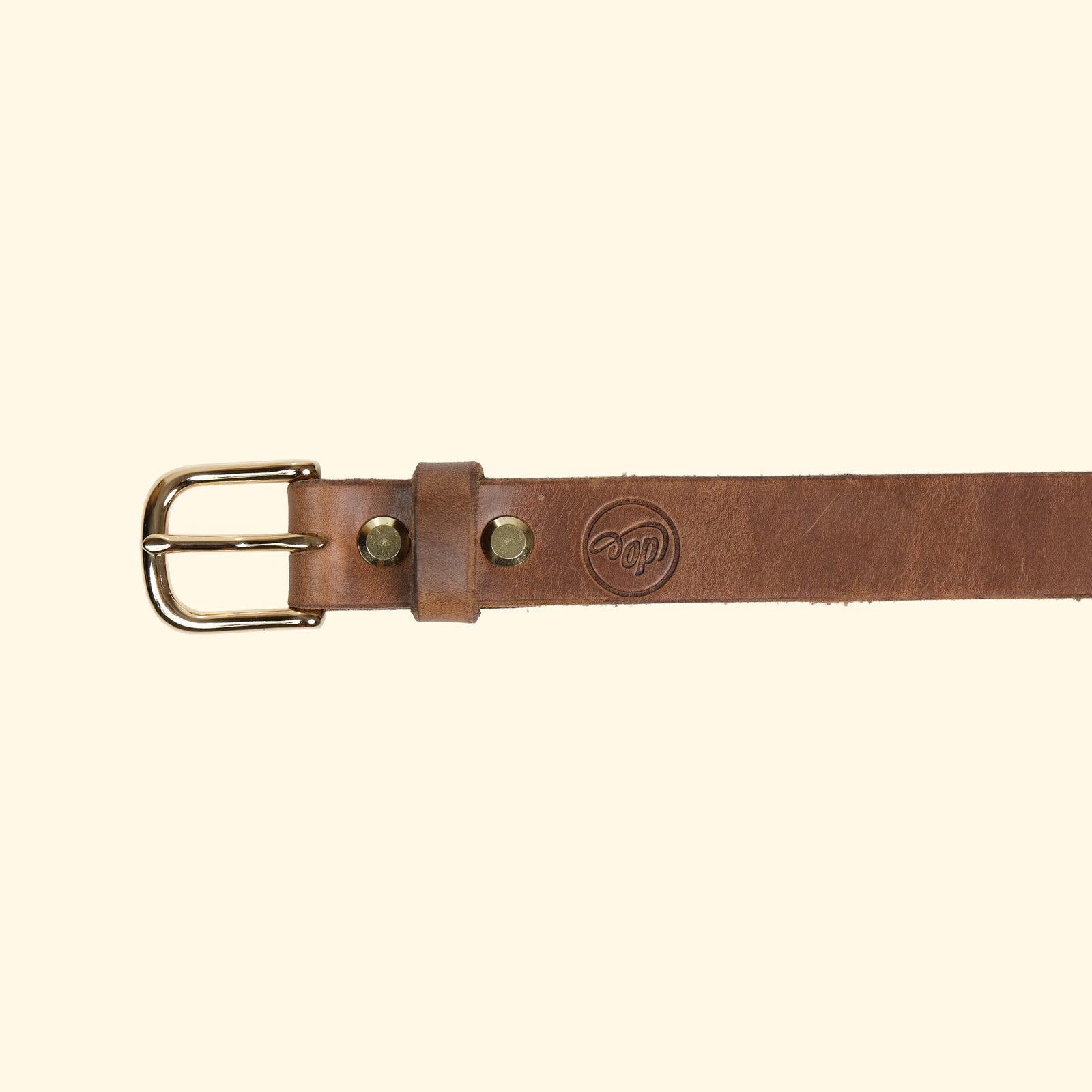 Aussenseite des oldpassion Gürtelmodells op belt slim aus Horween Chromexcel in Natural mit goldfarbener Dornschliesse, Lederschlaufe und dezentem Präglogo.