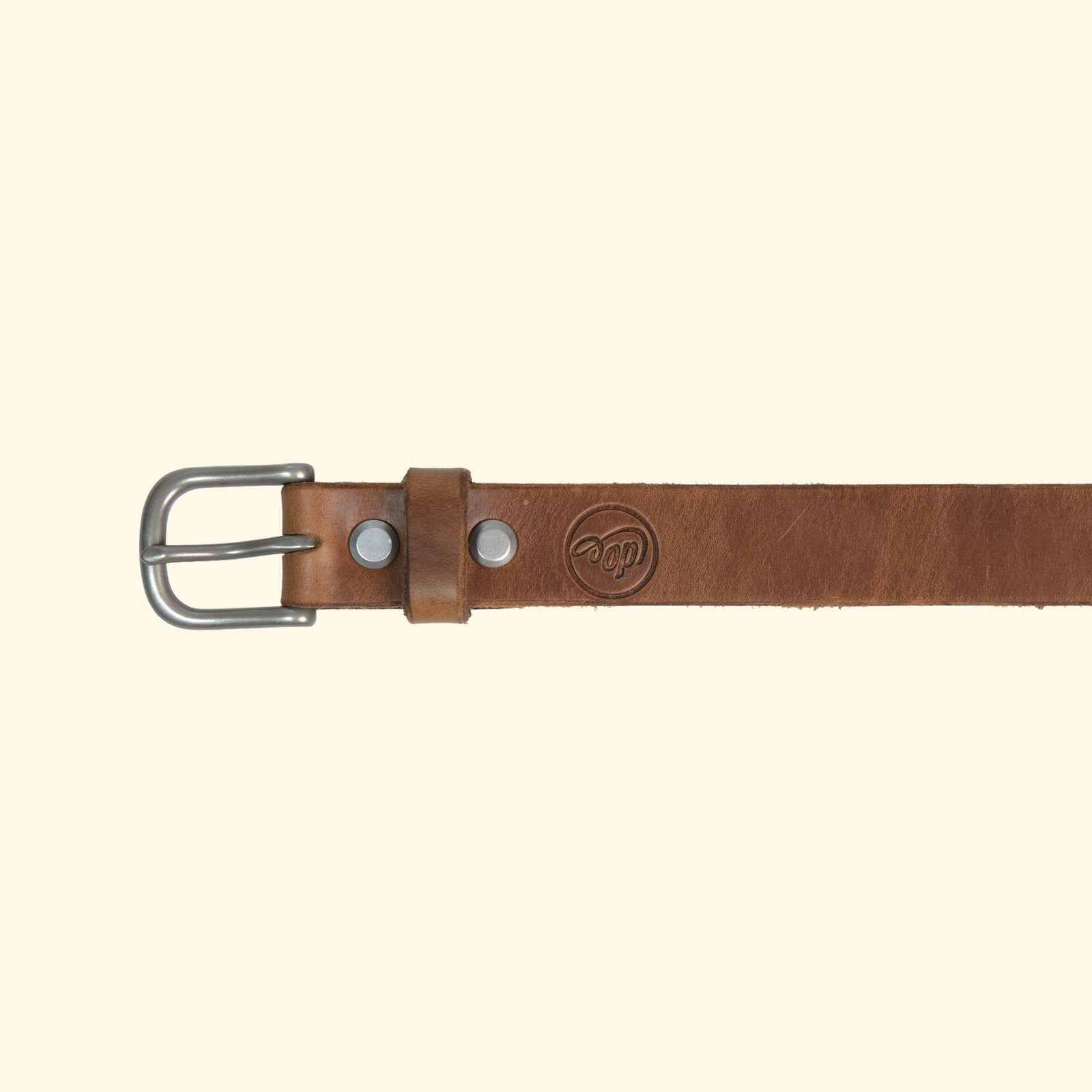 Aussenseite des oldpassion Gürtelmodells op belt slim aus Horween Chromexcel in Natural mit silberfarbener Dornschliesse, Lederschlaufe und Präglogo.