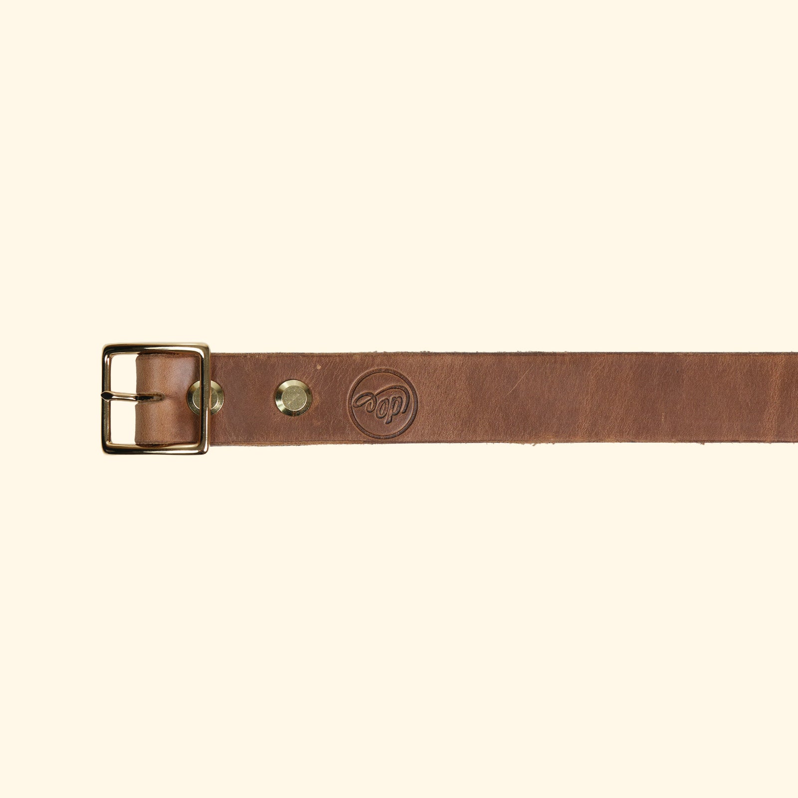 Aussenseite des oldpassion Gürtelmodells op belt slim aus Horween Chromexcel in Natural mit goldfarbener Mittelsteg-Dornschliesse und Präglogo.  