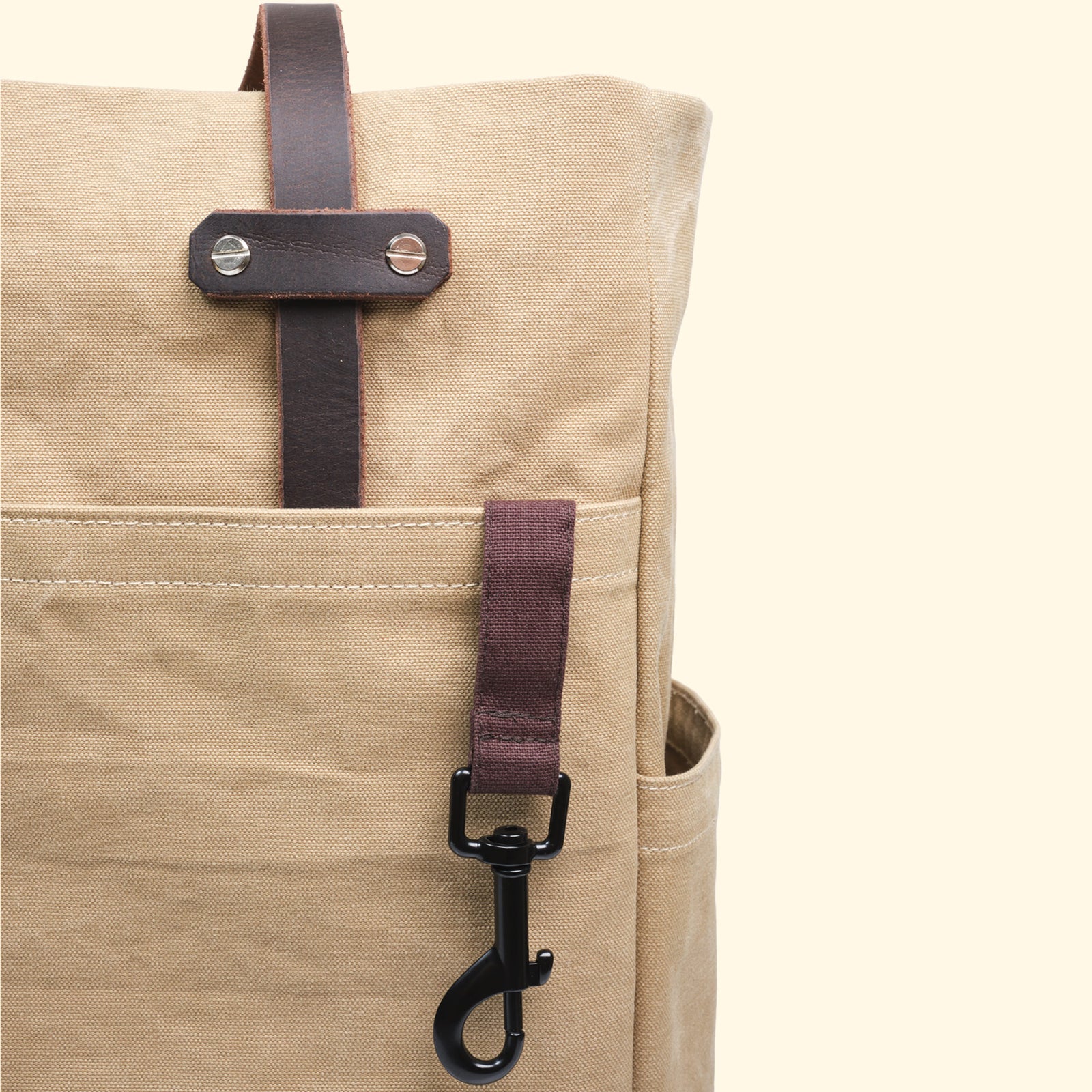 Detailansicht des schwarzen Karabinerhakens an der Canvas Tote Bag in Sand von oldpassion – robust, funktional und mit Baumwollschlaufe befestigt.