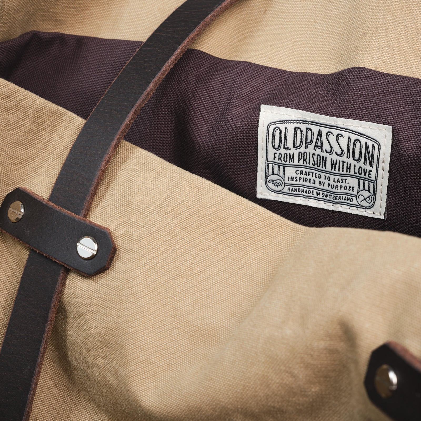 Nahaufnahme des oldpassion-Labels in der sandfarbenen Canvas Tote Bag – mit dem Leitsatz "From Prison With Love", handgemacht in der Schweiz.